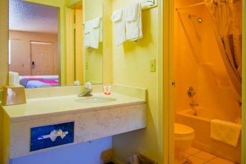 a bathroom with a sink and a toilet and a mirror at Duncan Inn by OYO, OK - Hwy 81 Near Chisholm Casino in Duncan