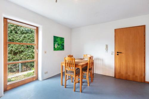 a dining room with a table and chairs and a window at Sonnige Wohnung im Markgräflerland in Efringen-Kirchen