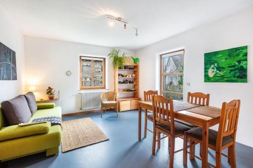 a living room with a table and a yellow couch at Sonnige Wohnung im Markgräflerland in Efringen-Kirchen