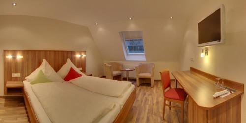 a hotel room with a bed and a table at Landgasthof Rebstock in Ottenhöfen
