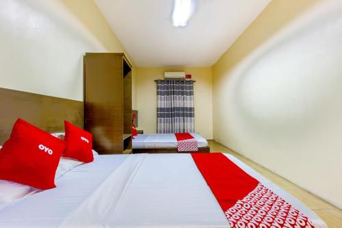 a bedroom with a large bed with red pillows at Metro Deluxe Residences in Manila