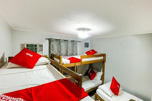 a dorm room with two bunk beds and red pillows at Metro Deluxe Residences in Manila