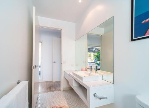 a bathroom with a sink and a mirror at Signature Accommodation Montez House Pool Retreat in Castlemaine