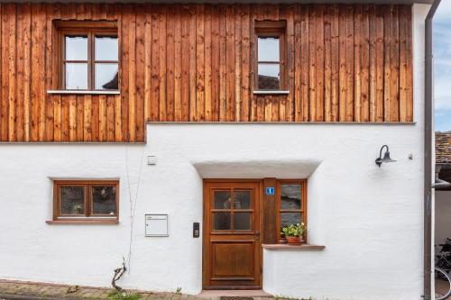 a house with a wooden facade and a door at Sonnige Wohnung im Markgräflerland in Efringen-Kirchen