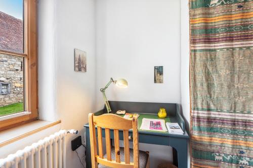 a desk with a lamp and a chair next to a window at Sonnige Wohnung im Markgräflerland in Efringen-Kirchen