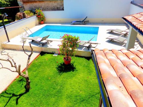 a backyard with a swimming pool with chairs and plants at Cozy Holiday Home in Valtura with Swimming Pool in Valtura