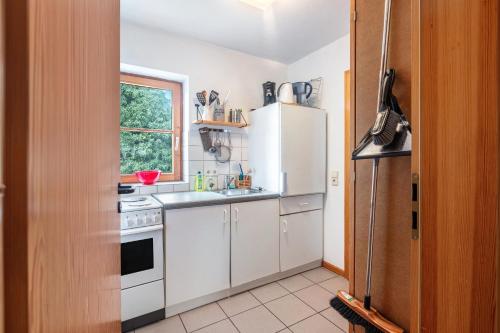 a kitchen with white cabinets and a white refrigerator at Sonnige Wohnung im Markgräflerland in Efringen-Kirchen