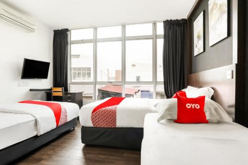 a hotel room with two beds and a large window at Hotel O Kl2f Rest & Go in Shah Alam