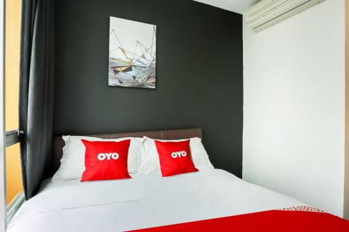 a bed with two red pillows in a bedroom at Hotel O Kl2f Rest & Go in Shah Alam
