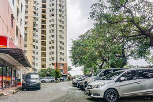 a row of cars parked in front of a tall building at OYO 90949 Apartement Cibubur Village Kaisar Property in Depok