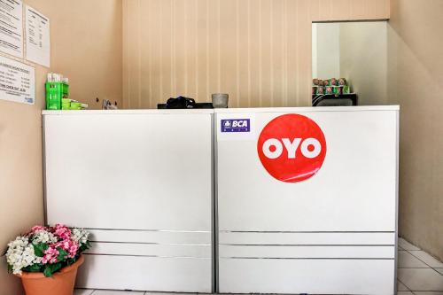 a white refrigerator with a noo sign on it at OYO 90949 Apartement Cibubur Village Kaisar Property in Depok