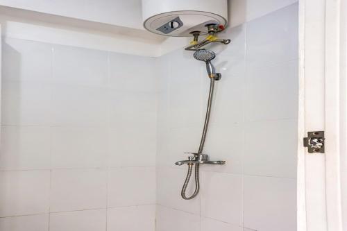 a shower with a shower head in a bathroom at OYO 90949 Apartement Cibubur Village Kaisar Property in Depok