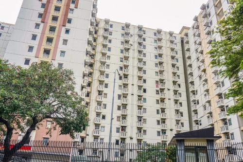 a tall building with a fence in front of it at OYO 90949 Apartement Cibubur Village Kaisar Property in Depok