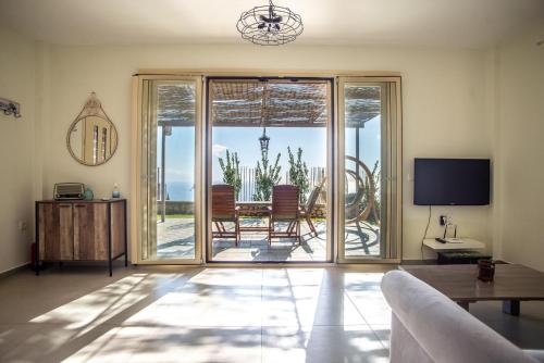 a living room with a view of a table and chairs at The Cerulean Villa - The Concord Of Blue And Green in Mousata