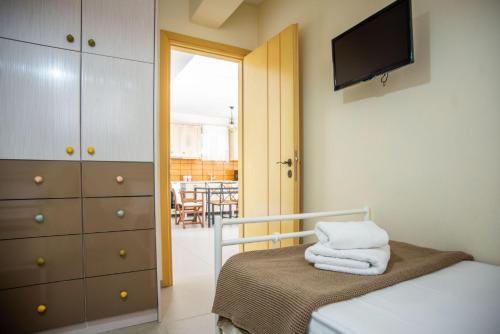 a small bedroom with a bed and a tv at The Cerulean Villa - The Concord Of Blue And Green in Mousata