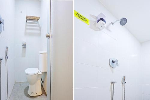 a white bathroom with a toilet and a shower at Hotel O Marina World in Kuching