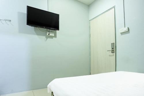 a white room with a tv on the wall at Hotel O Marina World in Kuching