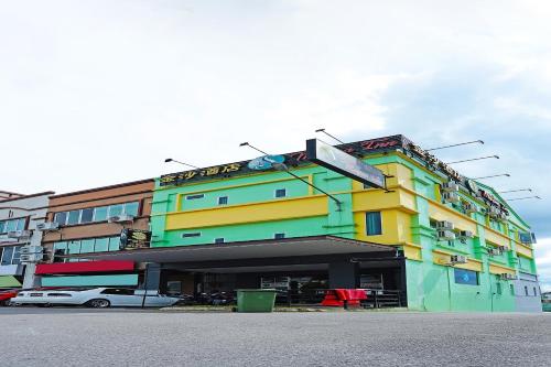 a colorful building with cars parked in front of it at Hotel O Marina World in Kuching