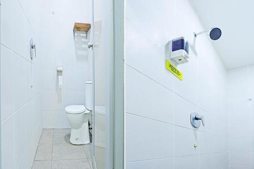 a white bathroom with a toilet and a shower at Hotel O Marina World in Kuching