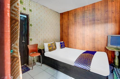 a small bedroom with a bed and a television at OYO Life 91060 Villa Wijaya Homestay in Pasuruan