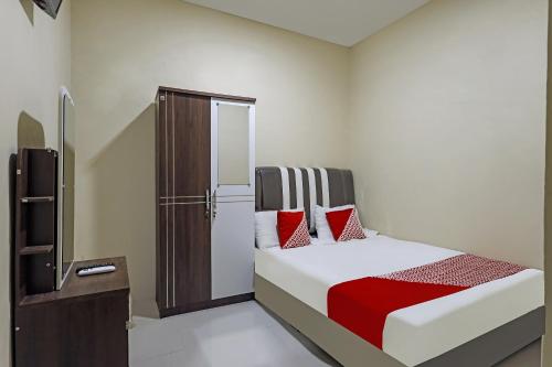 ein Schlafzimmer mit einem Bett mit roten Kissen in der Unterkunft OYO 90981 X2 Homestay in Nagoya