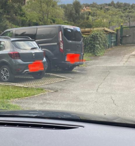 two cars parked in a parking lot next to a van at Nenè al mare appartamento con posto auto wifi e idromassaggio in Santa Margherita Ligure