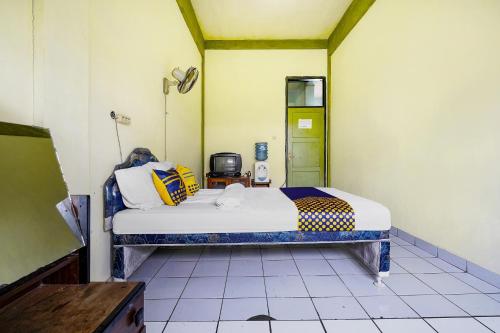 a small room with a bed in a room at Hotel O Wisma Lec Syariah in Garut
