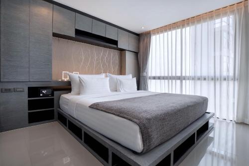 a bedroom with a large bed and a window at Tropics Kamala Residence CTG L709, Several Pools, near Phuket Fantasea & Beach in Kamala Beach