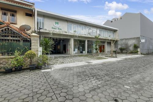 a building with a cobblestone street in front of it at Capital O 90983 Harmony Easy Stay in Yogyakarta