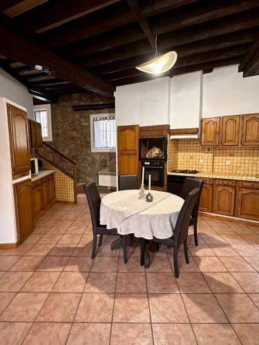 une cuisine avec une table et des chaises dans une pièce dans l'établissement Maison de village en pierre, à Saint-Laurent-de-Cerdans