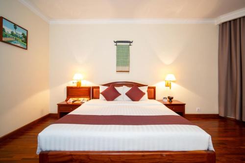 a bedroom with a large bed and two night stands at Khemara Angkor Hotel & Spa in Siem Reap