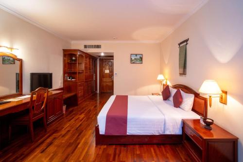 a bedroom with a bed and a desk and a computer at Khemara Angkor Hotel & Spa in Siem Reap