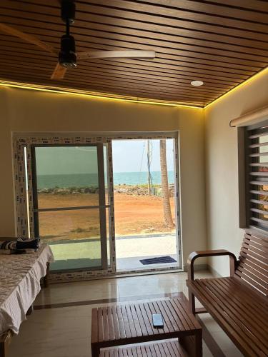 a room with a window with a view of the ocean at White Waves Beach Front Villa in Kaup