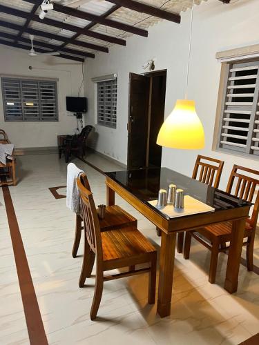 a dining table and chairs in a living room at White Waves Beach Front Villa in Kaup
