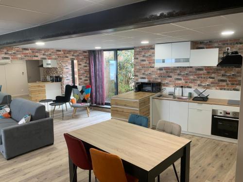une cuisine et un salon avec une table et des chaises dans l'établissement BeL F2, jardin privatif et calme, à Issoire