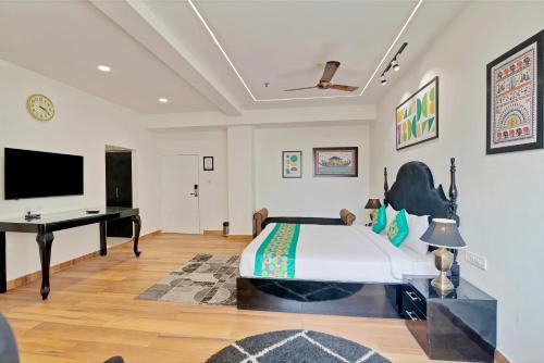 a bedroom with a bed and a desk and a television at Treebo Moon Waalk, Patia in Bhubaneshwar
