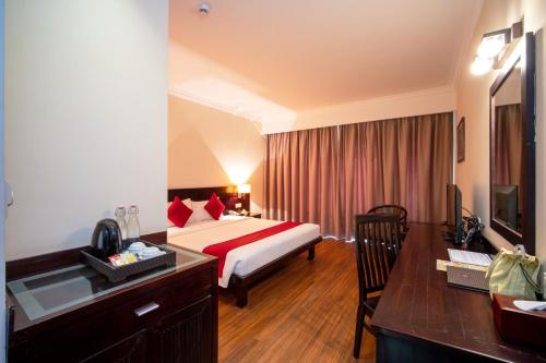 a hotel room with a bed and a desk at Khemara Angkor Hotel & Spa in Siem Reap