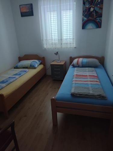 a bedroom with two beds and a lamp on a table at Apartmaji Jelena Piran in Piran