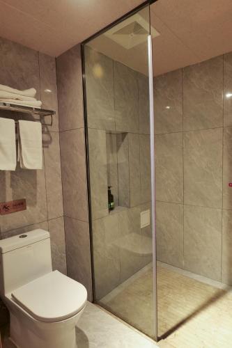 a bathroom with a toilet and a glass shower at Xizha River View Homestay in Fenghuang