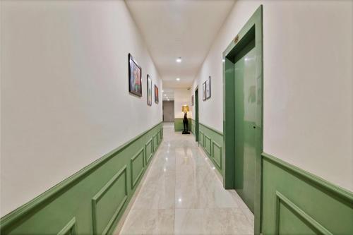 a hallway with green and white walls and a green door at Treebo Moon Waalk, Patia in Bhubaneshwar