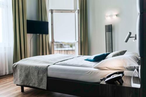 a bedroom with a large bed with a window at Best Western Hotel Kurfürst Wilhelm I. in Kassel