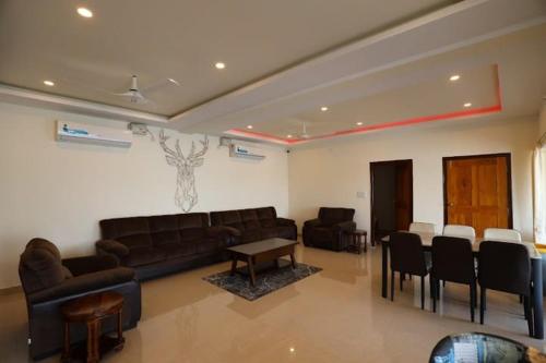 a living room with a couch and a table and chairs at Blue Dolphin homestay in Tadri