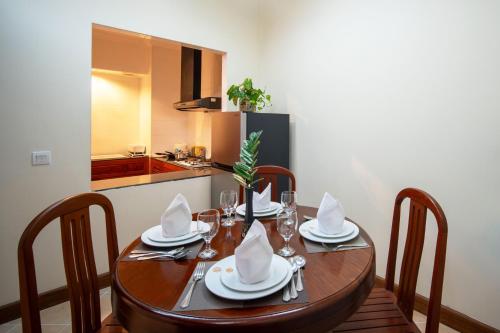 a dining room table with chairs and a kitchen at Khemara Angkor Hotel & Spa in Siem Reap