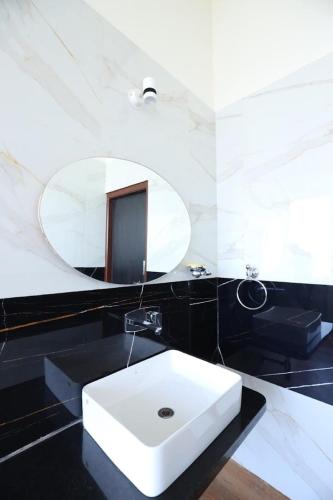 a bathroom with a white sink and a mirror at Blue Dolphin homestay in Tadri