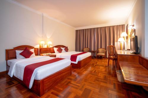 a hotel room with two beds and a television at Khemara Angkor Hotel & Spa in Siem Reap