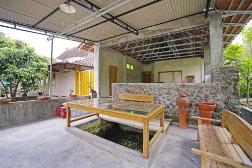 a patio with a bench and a fish pond at Hotel O Griya Estu Wening in Sleman