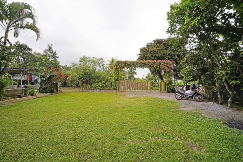 a motorcycle parked in a yard next to a fence at Hotel O Griya Estu Wening in Sleman