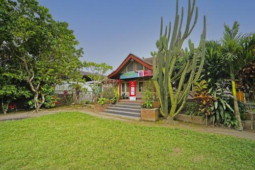 a house with a red door and a green yard at Hotel O Griya Estu Wening in Sleman