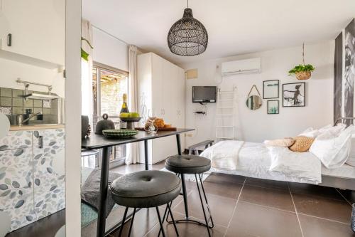 Schlafzimmer mit einem Bett, einem Tisch und Stühlen in der Unterkunft Cozy Givat Ada Countryside Stay in Giv‘at ‘Ada