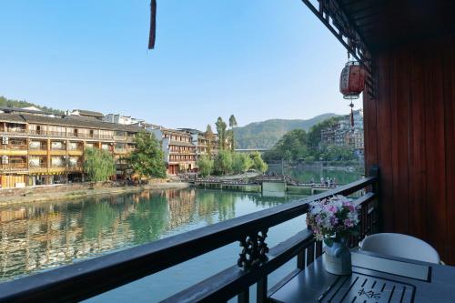 a balcony with a view of a river and buildings at Xizha River View Homestay in Fenghuang